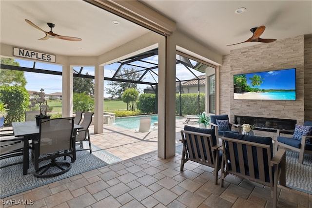 view of patio featuring glass enclosure, ceiling fan, and outdoor lounge area