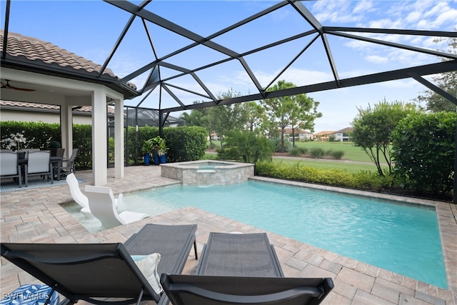 view of swimming pool with glass enclosure, an in ground hot tub, ceiling fan, and a patio area