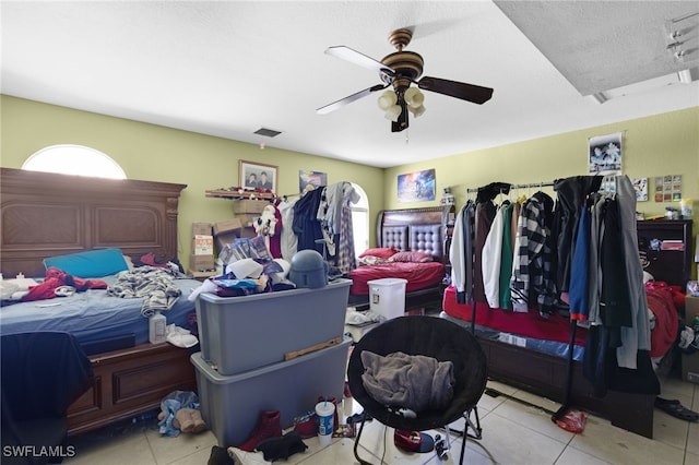 tiled bedroom featuring a textured ceiling and ceiling fan