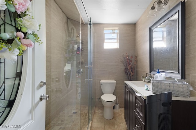 bathroom with vanity, an enclosed shower, tile patterned floors, tile walls, and toilet