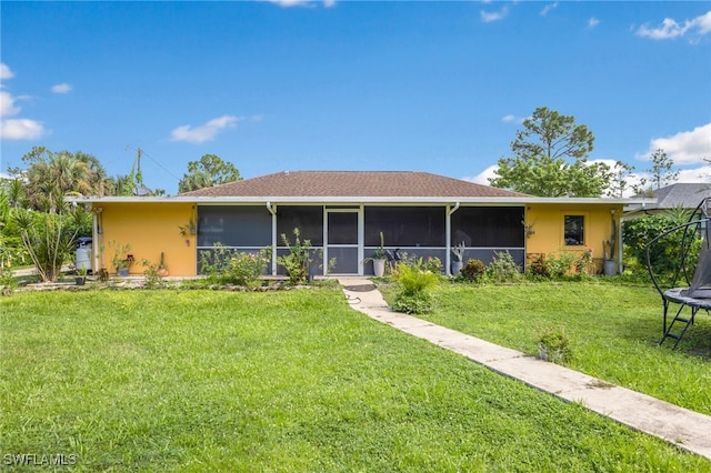 ranch-style house with a sunroom, a trampoline, and a front yard