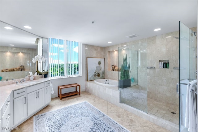 bathroom with vanity, tile patterned flooring, and plus walk in shower