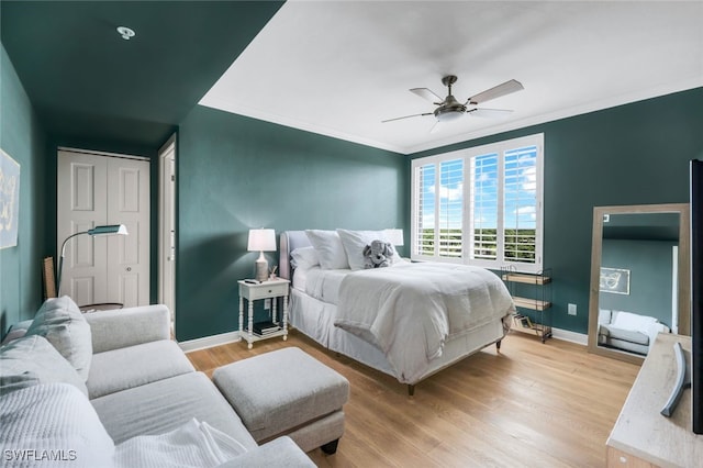 bedroom with ornamental molding, light wood-type flooring, and ceiling fan