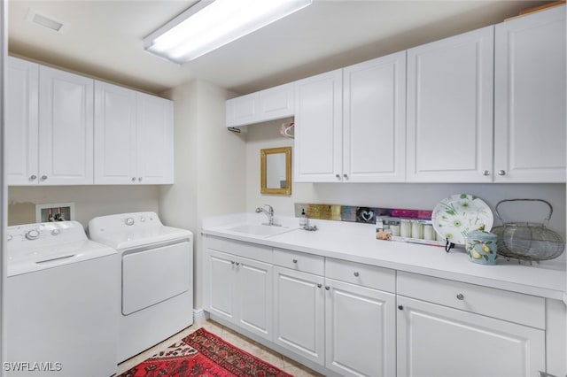 clothes washing area featuring sink, independent washer and dryer, and cabinets