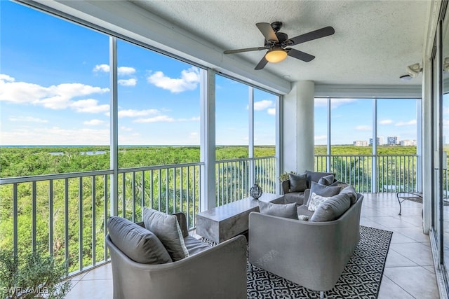 sunroom / solarium with a water view and ceiling fan