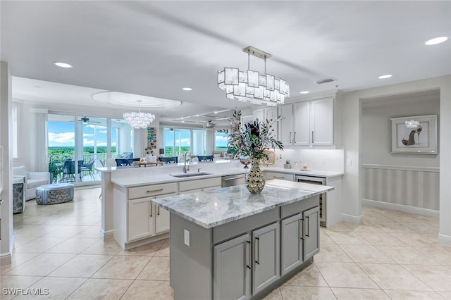 kitchen with dishwasher, hanging light fixtures, sink, a center island, and beverage cooler