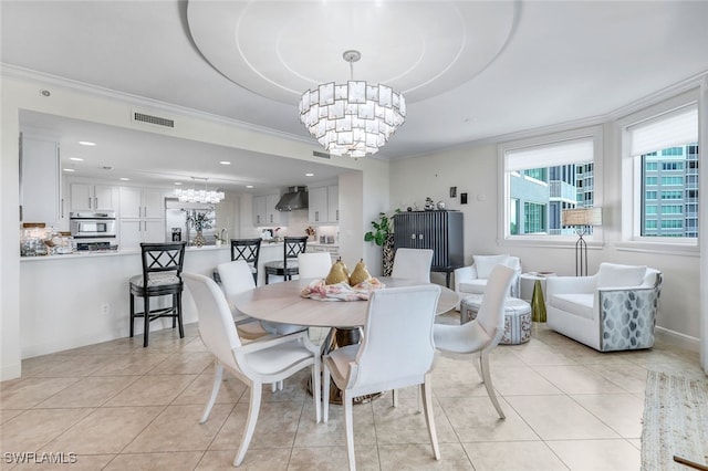 dining area with a raised ceiling, ornamental molding, light tile patterned flooring, and a chandelier