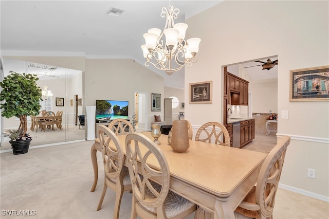 carpeted dining space featuring ceiling fan with notable chandelier, vaulted ceiling, and sink