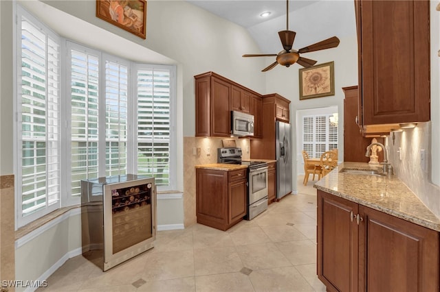 kitchen with ceiling fan, stainless steel appliances, tasteful backsplash, beverage cooler, and sink