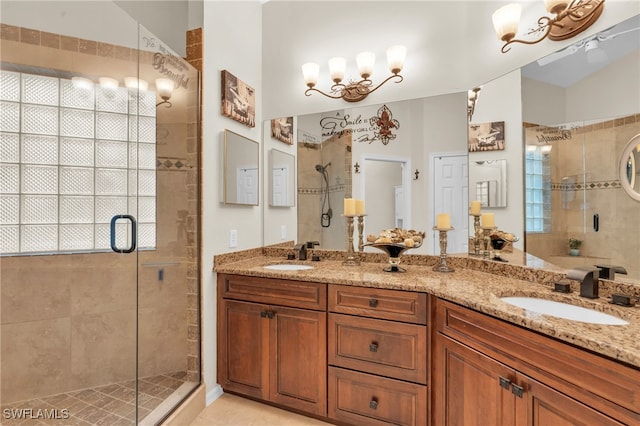 bathroom with an inviting chandelier, vanity, and a shower with shower door