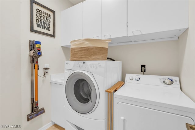 clothes washing area with independent washer and dryer and cabinets