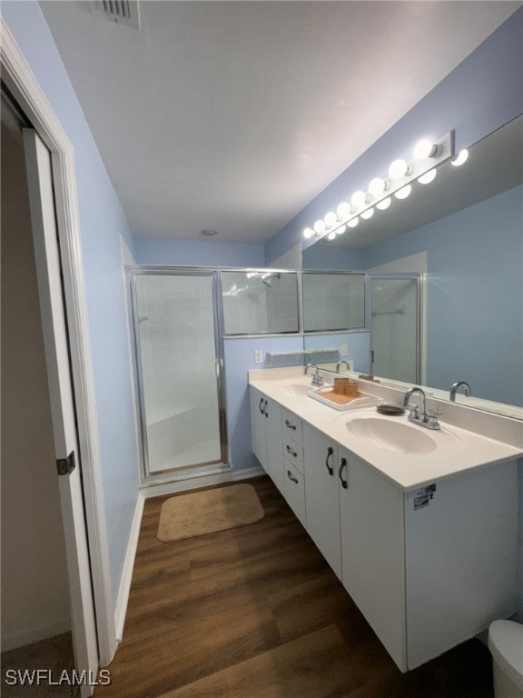 bathroom with walk in shower, vanity, hardwood / wood-style floors, and toilet