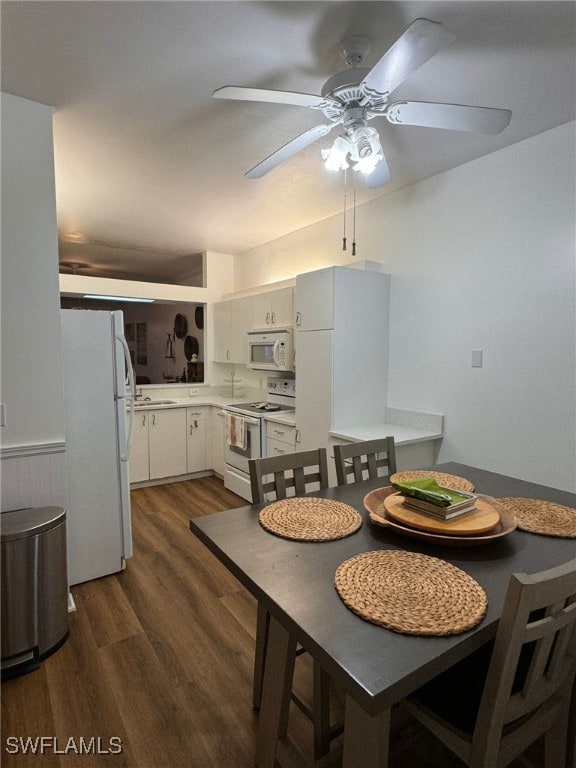 dining area featuring ceiling fan, sink, and dark hardwood / wood-style flooring