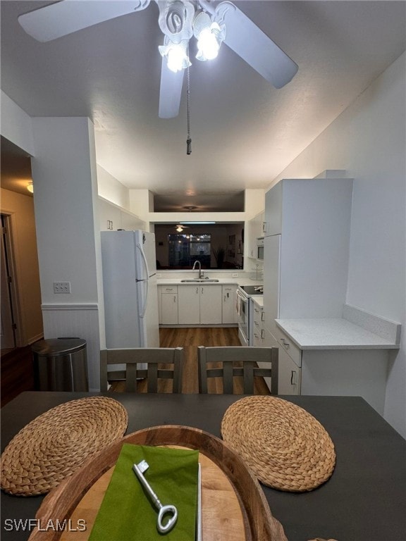 dining area featuring ceiling fan, wooden walls, and sink