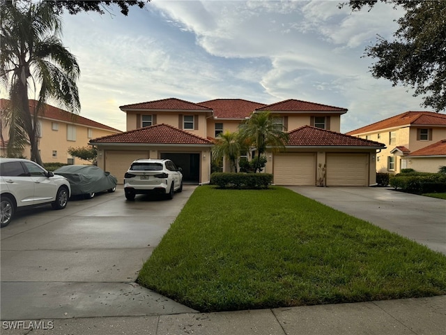 mediterranean / spanish home with a garage and a front lawn