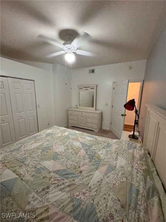 bedroom with a textured ceiling, ceiling fan, and a closet