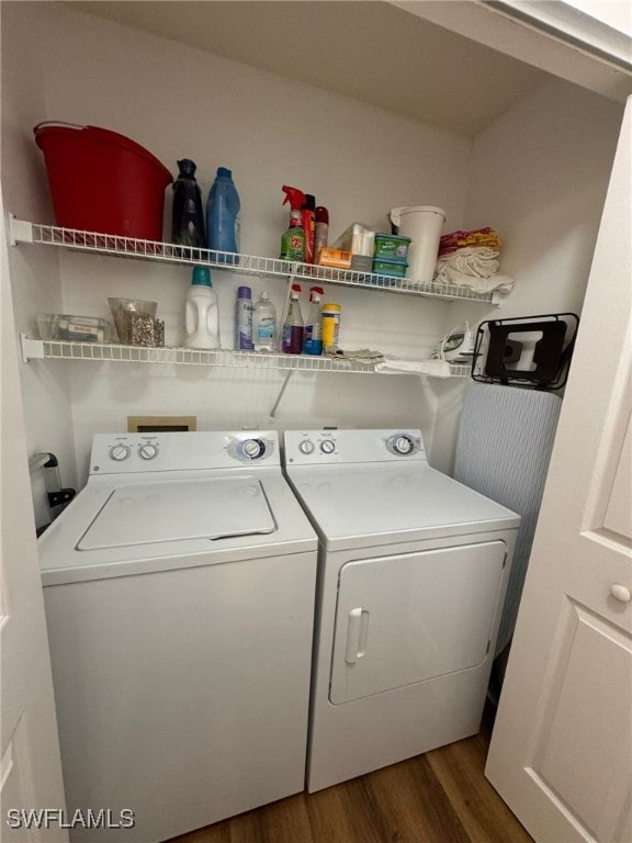 laundry area with washing machine and clothes dryer and dark hardwood / wood-style flooring