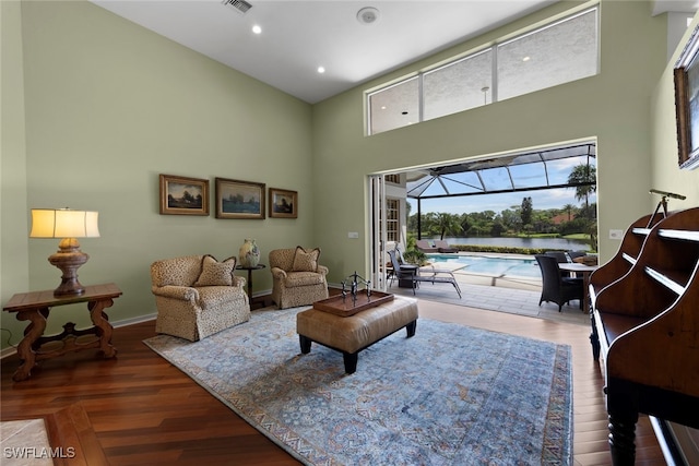 living room featuring hardwood / wood-style floors and a towering ceiling