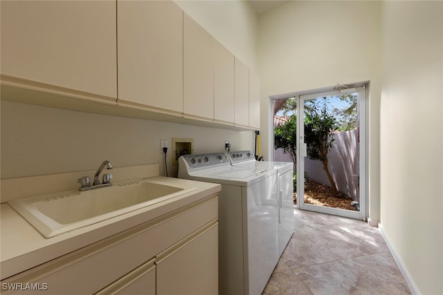 washroom featuring light tile patterned flooring, sink, cabinets, a high ceiling, and washing machine and dryer