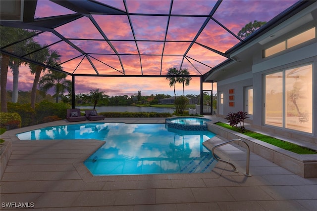 pool at dusk with a patio, an in ground hot tub, a lanai, and a water view