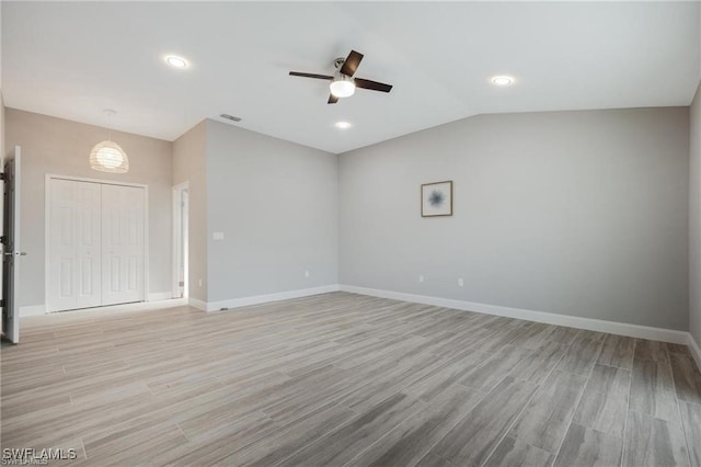 unfurnished room with ceiling fan, vaulted ceiling, and light hardwood / wood-style floors