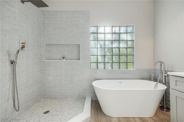 bathroom featuring tile walls, hardwood / wood-style floors, vanity, and separate shower and tub