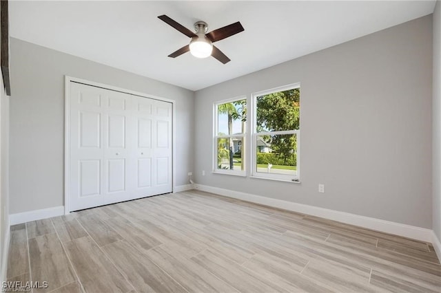 unfurnished bedroom featuring ceiling fan, a closet, and light hardwood / wood-style flooring