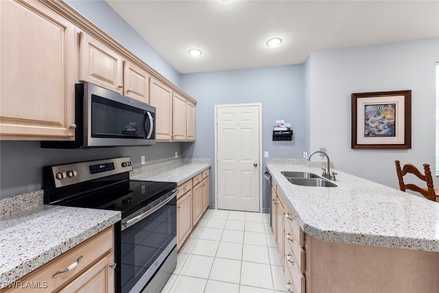 kitchen featuring appliances with stainless steel finishes, light brown cabinets, sink, and light stone counters