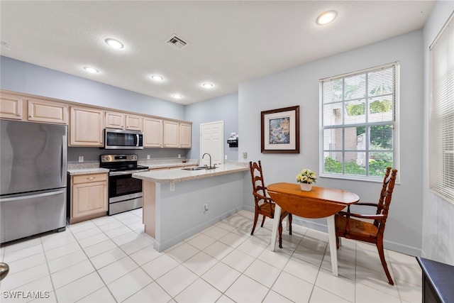 kitchen with sink, light brown cabinets, kitchen peninsula, and stainless steel appliances