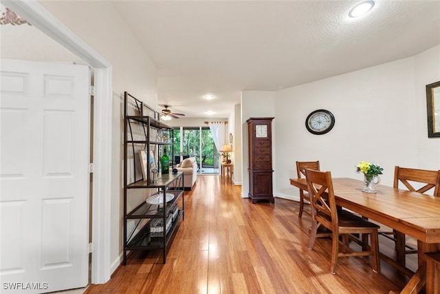 dining space featuring light hardwood / wood-style floors, a textured ceiling, and ceiling fan