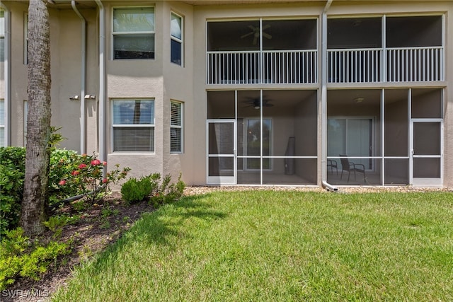 rear view of property featuring a sunroom and a yard