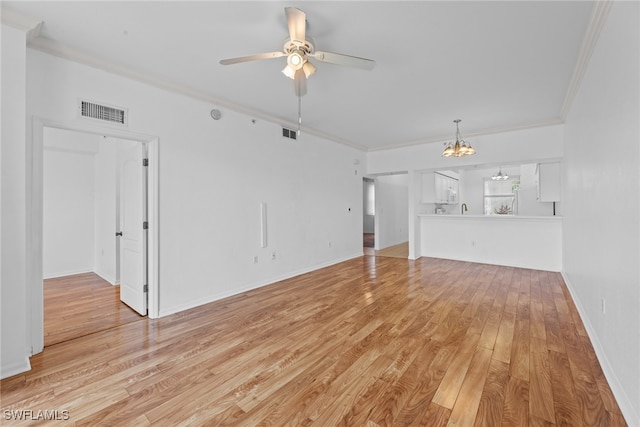 unfurnished living room featuring ceiling fan with notable chandelier, light hardwood / wood-style flooring, and ornamental molding