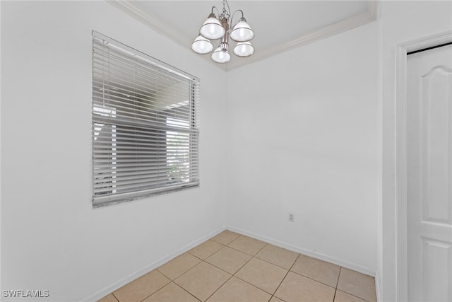 tiled spare room featuring crown molding and a chandelier