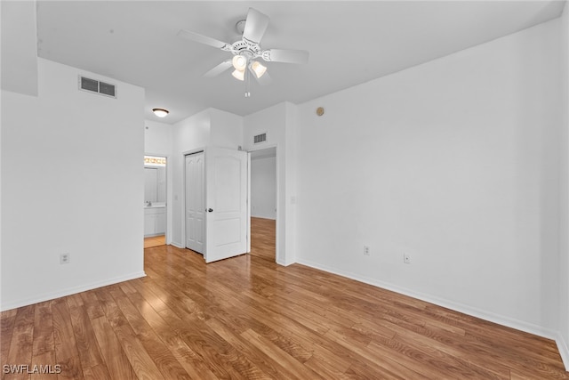 unfurnished bedroom with light hardwood / wood-style floors, ensuite bath, and ceiling fan