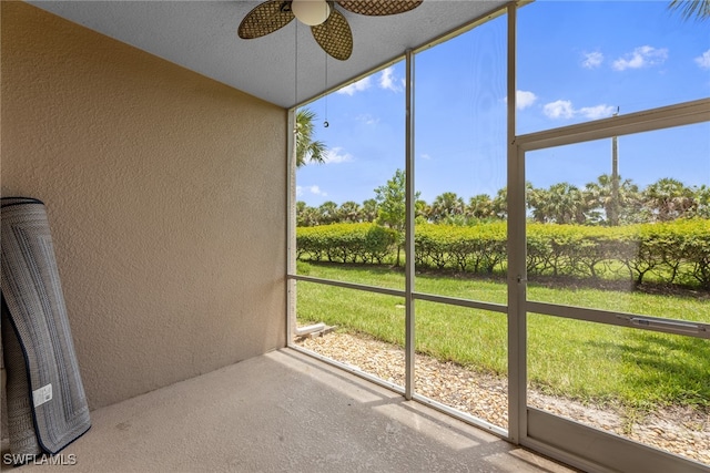 unfurnished sunroom with ceiling fan