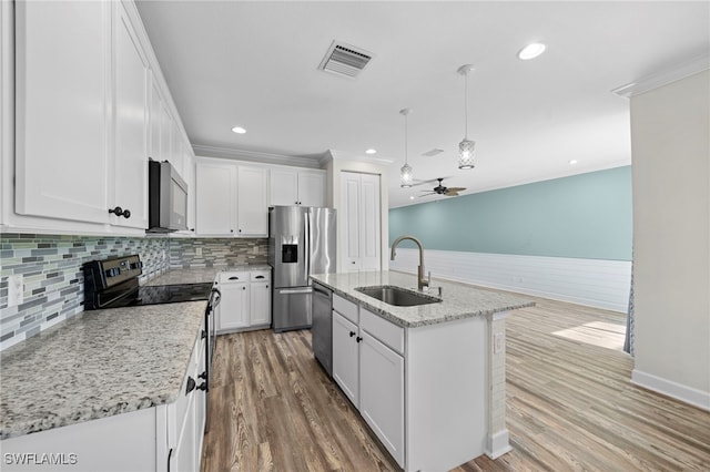 kitchen featuring appliances with stainless steel finishes, white cabinets, ceiling fan, a kitchen island with sink, and sink