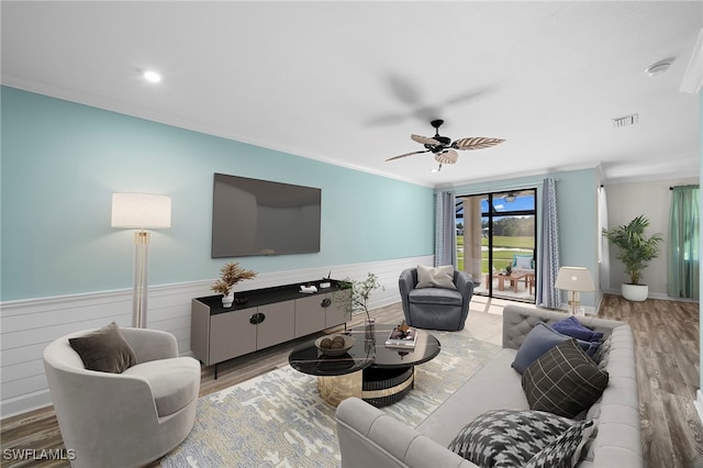 living room featuring crown molding, hardwood / wood-style floors, and ceiling fan