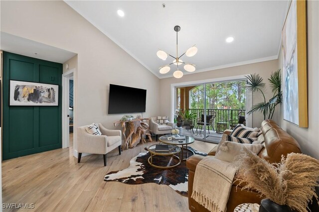 living room with ornamental molding, an inviting chandelier, light hardwood / wood-style floors, and high vaulted ceiling