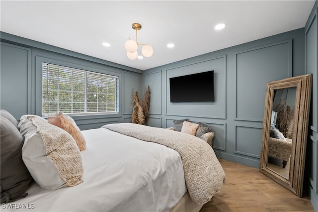 bedroom featuring light hardwood / wood-style flooring and a chandelier