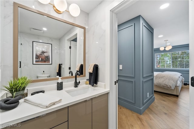 bathroom featuring vanity, hardwood / wood-style floors, and a shower with door