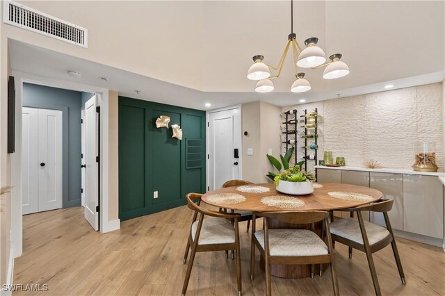 dining area featuring light wood-type flooring and a chandelier