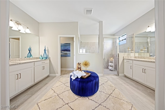 bathroom featuring hardwood / wood-style flooring, walk in shower, and vanity