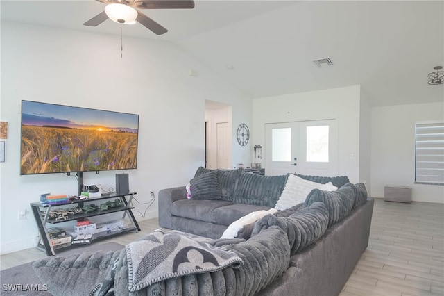 living room featuring light wood-type flooring, vaulted ceiling, ceiling fan, and french doors