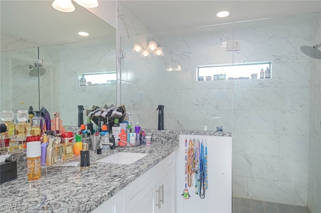 bathroom featuring a tile shower and vanity