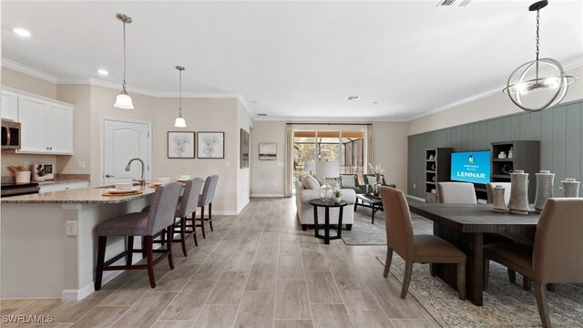 dining space featuring baseboards, visible vents, ornamental molding, and wood tiled floor