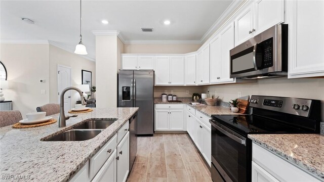 kitchen with a sink, white cabinetry, stainless steel appliances, visible vents, and ornamental molding