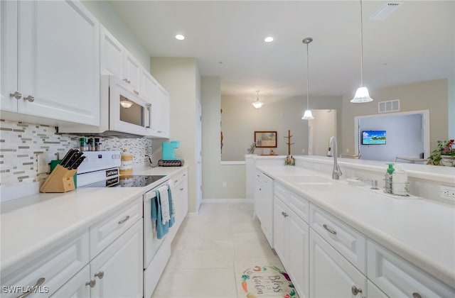 kitchen with white cabinets, light tile patterned floors, sink, white appliances, and decorative light fixtures