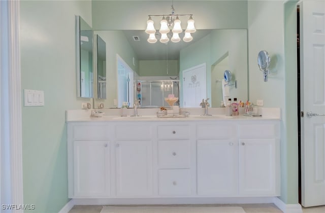 bathroom featuring a shower with door, vanity, and a chandelier