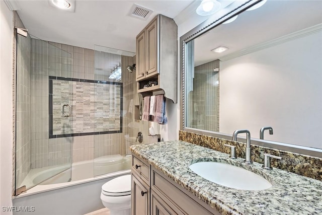 full bathroom with combined bath / shower with glass door, toilet, crown molding, and vanity