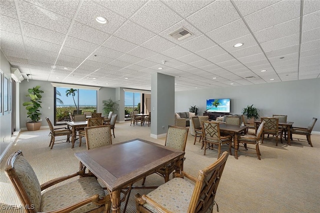 carpeted dining room featuring a paneled ceiling